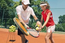 Tennislehrer arbeitet mit Teenagerschülerin. — Stockfoto