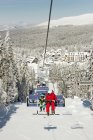 Father and son riding on ski lift at winter resort. — Stock Photo