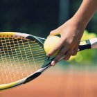 Close-up de tenista segurando bola contra raquete . — Fotografia de Stock