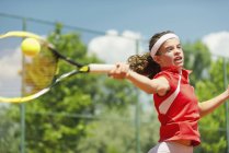 Plan d'action de la jeune joueuse de tennis frappant au premier plan . — Photo de stock