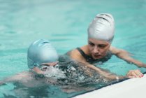 Istruttore di nuoto che lavora con il bambino in piscina . — Foto stock
