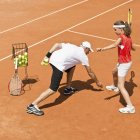 Инструктор по теннису работает с девочкой-подростком на глиняном корте
. — стоковое фото