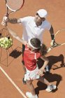Entrenador con jugador adolescente en clase de tenis . - foto de stock