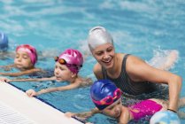 Female instructor with children in swimming pool. — Stock Photo