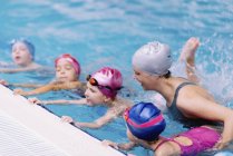Clase de natación con instructor para niños en piscina . - foto de stock