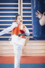 Criança chutando saco de soco na classe taekwondo . — Fotografia de Stock