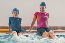 Boy in swimming class with instructor in public pool. — Stock Photo