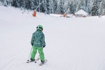 Bambino in abbigliamento invernale sciare sulle montagne innevate . — Foto stock