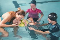 Жінка з сином має урок плавання з інструкторами в басейні . — стокове фото