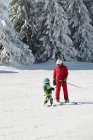 Ski class with male instructor and little boy in snowy mountains. — Stock Photo