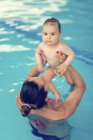 Mother playing with baby boy in swimming pool. — Stock Photo