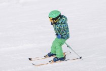 Kleiner Junge in Winterkleidung beim Skifahren auf schneebedeckten Bergen. — Stockfoto