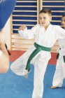 Boy and girl training in Taekwondo class with trainer. — Stock Photo