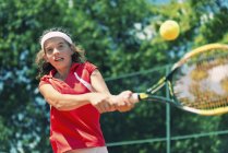 Adolescent joueur de tennis frapper balle au dos . — Photo de stock