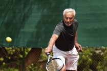 Чоловік старший гравець практикує теніс на корті . — стокове фото