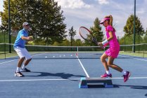 Adolescente ragazza in allenamento di tennis sul campo con istruttore maschio . — Foto stock