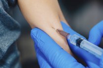 Médecin faisant la vaccination de seringue au garçon d'âge préscolaire dans la clinique médicale . — Photo de stock