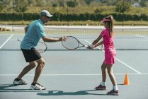 Tennis instructor training teenage girl on tennis court. — Stock Photo