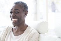 Mature woman smiling and laughing indoors. — Stock Photo