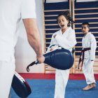 Taekwondo instructor training boy and girl in class. — Stock Photo