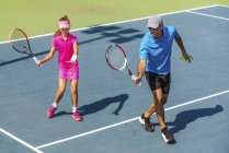 Treinamento de tenista adolescente com treinador masculino na quadra de tênis . — Fotografia de Stock