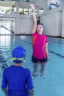 Carino bambino imparare a nuotare con istruttore femminile in piscina . — Foto stock
