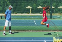 Дівчина-підліток стрибає мотузкою з тенісним тренером . — стокове фото