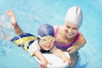 Little boy learning swimming with female instructor in swimming pool. — Stock Photo