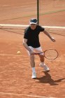 Hombre mayor activo jugando tenis con raqueta
. - foto de stock