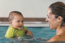 Lächelnder kleiner Junge mit Mutter im Schwimmbad. — Stockfoto