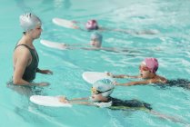 Instrutor de natação com crianças usando chutes na piscina . — Fotografia de Stock