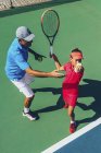 Adolescent tennis player practicing with male instructor in tennis class. — Stock Photo