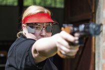 Mid adult woman practicing sports pistol shooting. — Stock Photo