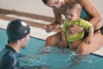 Mãe com menino e instrutor na aula de natação na piscina pública . — Fotografia de Stock