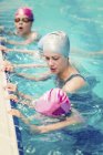 Дети практикуют дыхание с женщиной-инструктором в бассейне . — стоковое фото