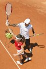 Entrenador con tenista adolescente practicando servir
. - foto de stock