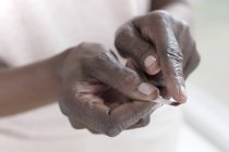 Close-up of hands of mature woman using paper strip to test blood glucose. — Stock Photo