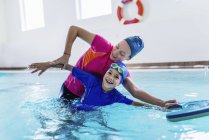 Мальчик учится плавать с женщиной-инструктором в бассейне . — стоковое фото