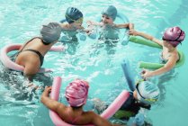 Instructor con grupo de niños divirtiéndose en la escuela de natación
. - foto de stock