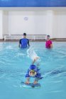 Menino ter aula de natação com instrutores na piscina . — Fotografia de Stock