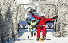 Father and son riding on ski lift at winter resort. — Stock Photo