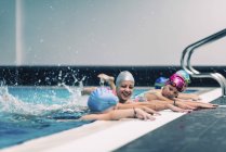 Female instructor with preschoolers while swimming lesson in pool. — Stock Photo