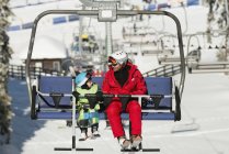 Vater und Sohn auf Skilift im Wintersportort. — Stockfoto