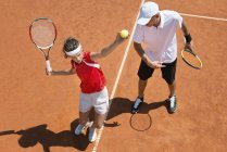 Підлітковий тенісист практикує сервіс з тенісним тренером . — стокове фото