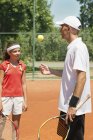 Instructor de tenis hablando con estudiante adolescente . - foto de stock