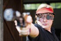 Mid adult woman practicing sports pistol shooting. — Stock Photo