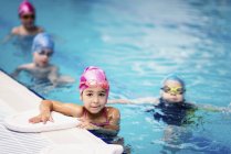 Gruppo di bambini in età prescolare durante la lezione di nuoto in acqua della piscina . — Foto stock
