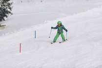 Мальчик в зимней одежде катается на лыжах по снежным горам
. — стоковое фото