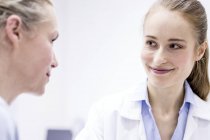 Doctor smiling to female patient during consultation. — Stock Photo
