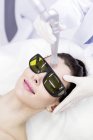 Técnico de beleza usando tratamento a laser no cliente feminino . — Fotografia de Stock
